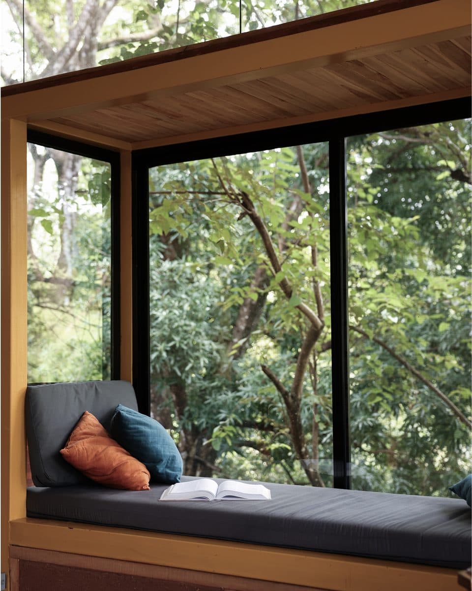 A resident resting on a daybed looking out into the forest