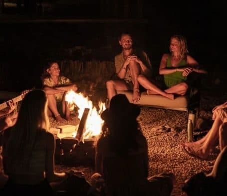 Residents gathered around a campfire at night