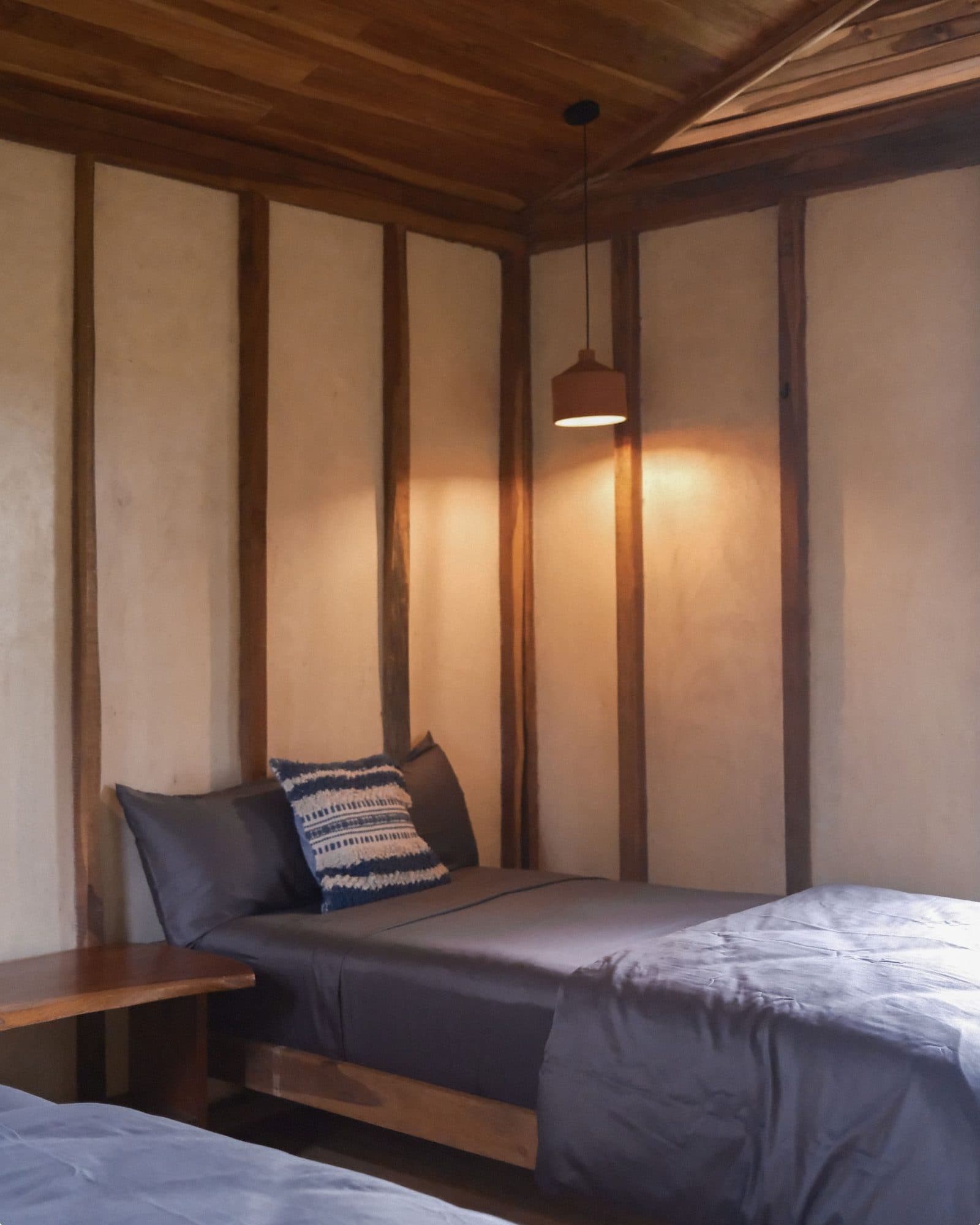 The interior of a casita bedroom with clay walls and wood beams