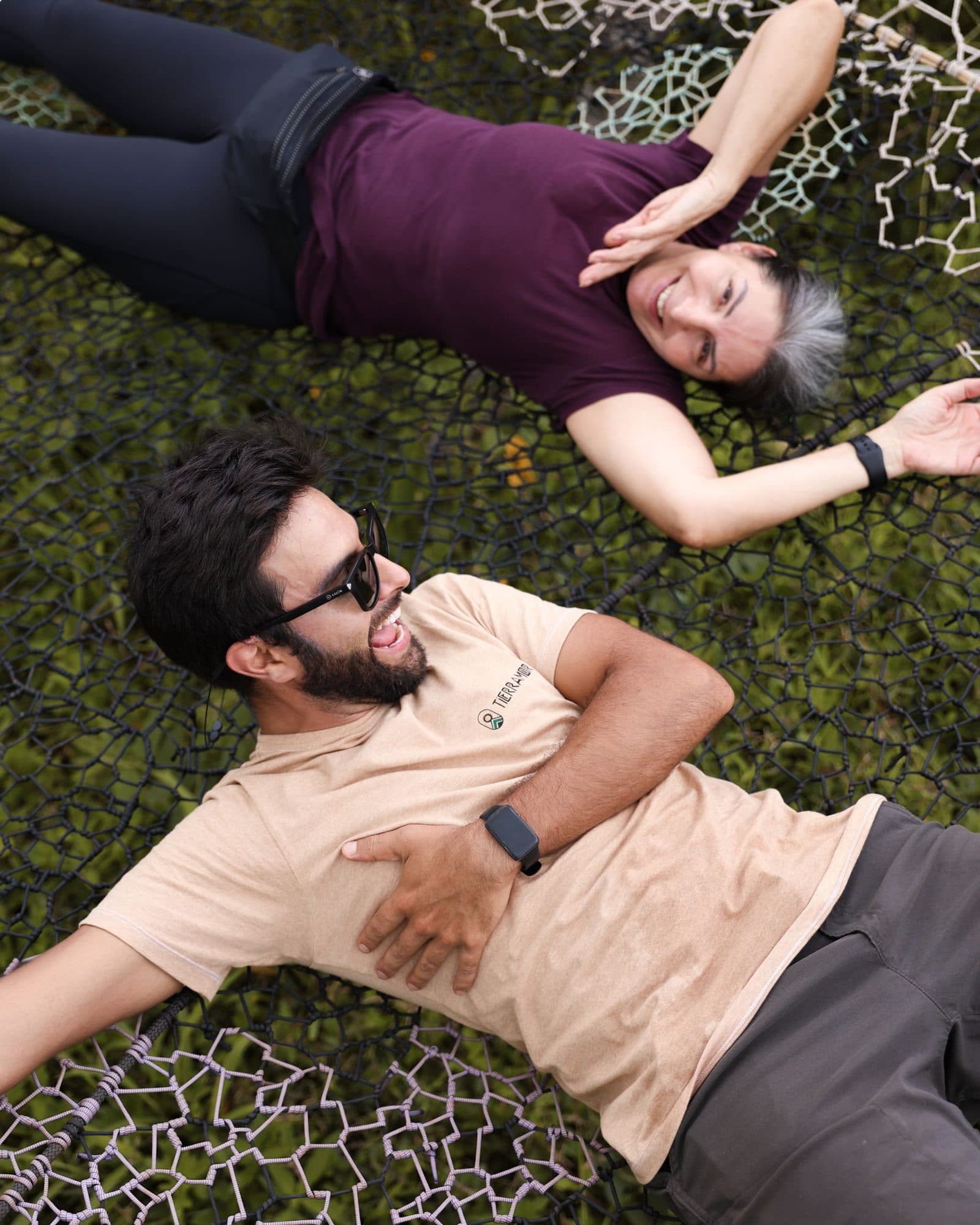 Two residents lying in the grass laughing