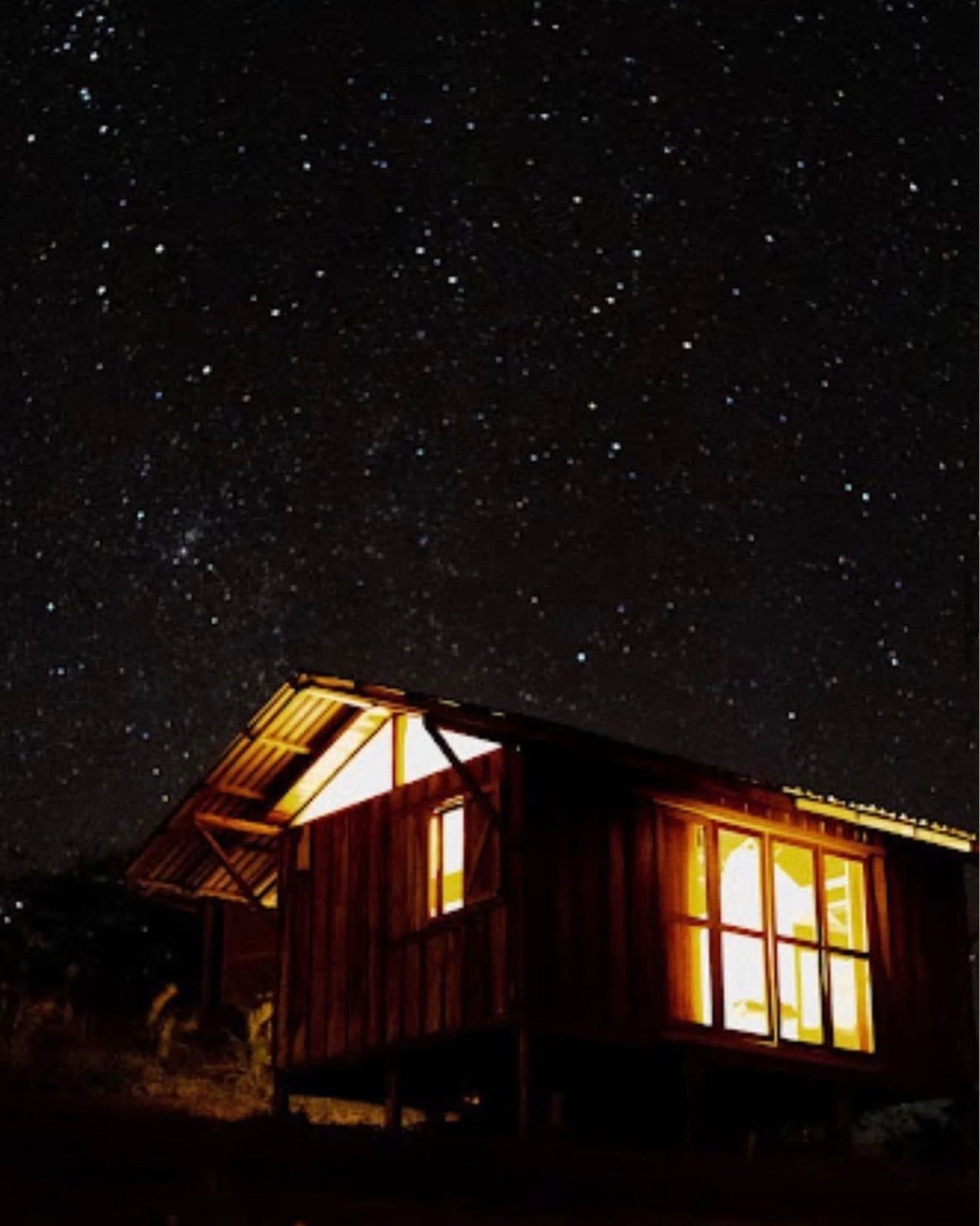 A casita lit up at night under a starry sky