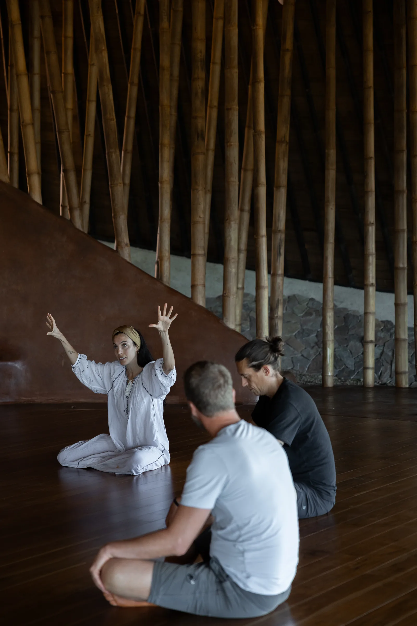 Residents moving together in the ceremony space, bamboo screen behind them